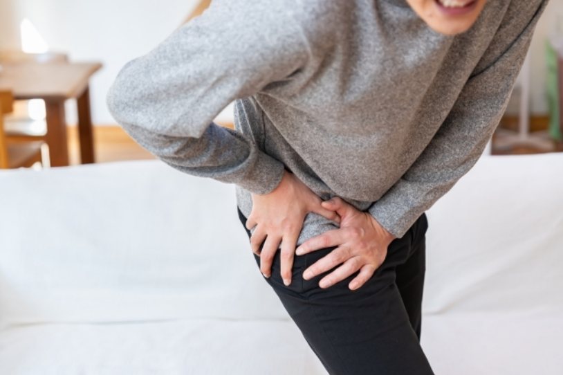 腰の痛みに悩む女性