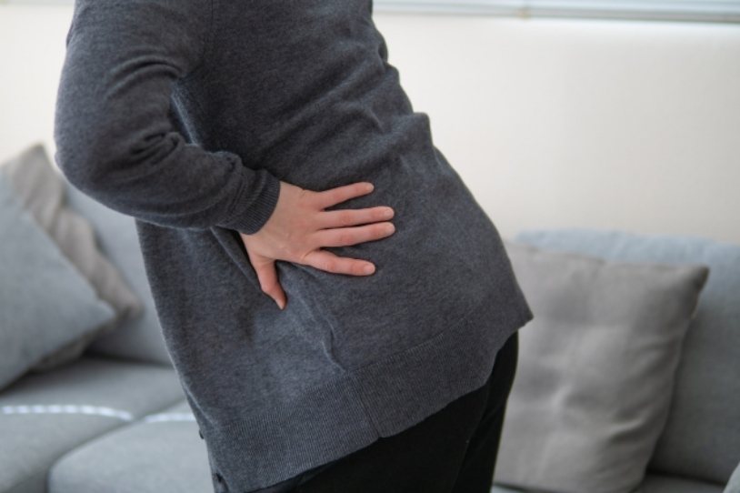 腰の痛みに悩む女性