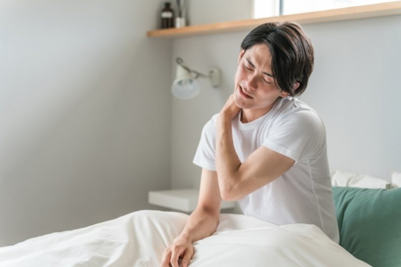 首の痛みで寝違えた男性
